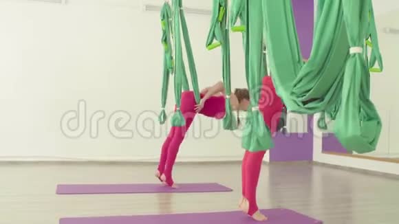 空中瑜伽两个女人坐在吊床上视频的预览图