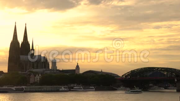 科隆大教堂后面日落船在德国莱茵河上航行视频的预览图