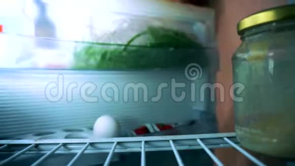 一个穿短裤的人打开冰箱他半空露出脸从冰箱里拿出一个罐子视频的预览图