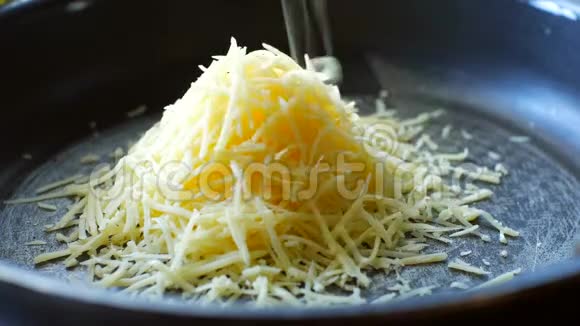 把磨碎的奶酪放在煎锅上加入奶油牛奶视频的预览图