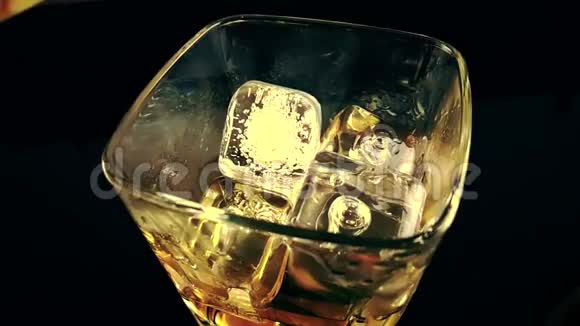 酒吧老板把威士忌倒在酒杯里杯底是冰块喝威士忌放松时间视频的预览图