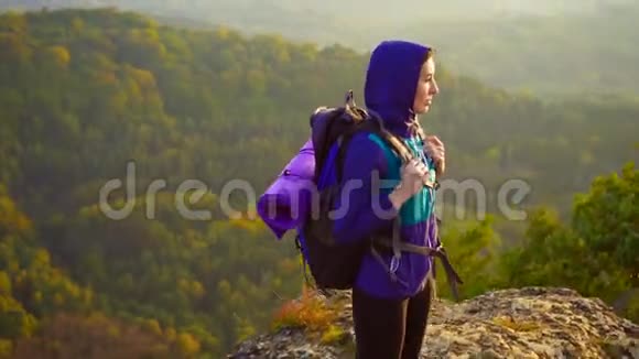 女游客在大风中背包的肖像视频的预览图