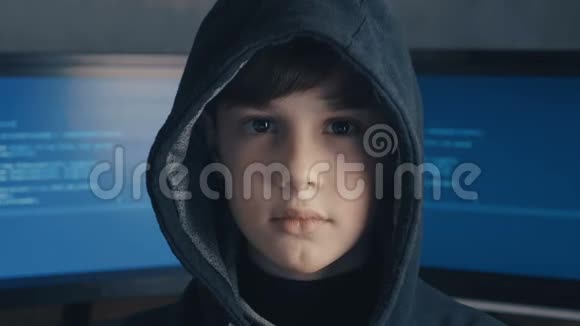 一个天才男孩黑客天才的肖像在引擎盖的背景显示器与程序代码年轻的黑客视频的预览图