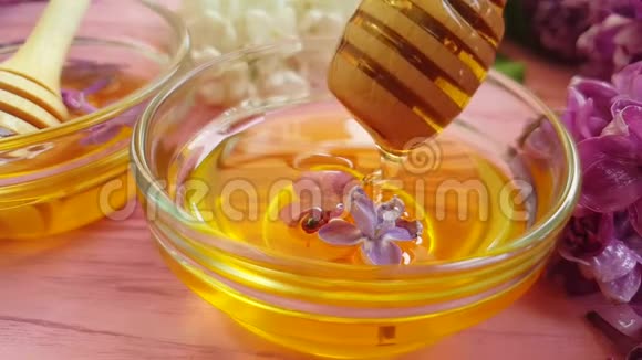 蜂蜜有机天然浇注美味的丁香花木制背景美味视频的预览图
