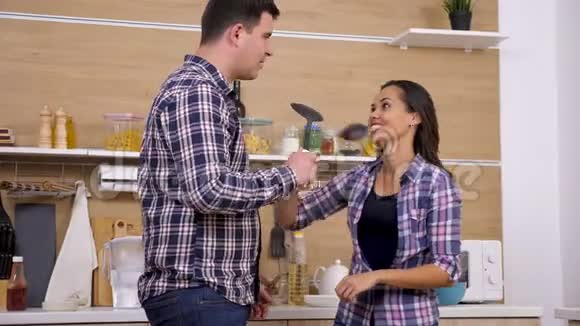 一对笑得很有趣的夫妇用大塑料勺子打架视频的预览图
