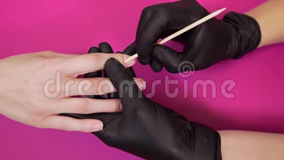 美甲师在美容院用木棍处理角质层女人美甲健康指甲涂指甲涂指甲视频的预览图