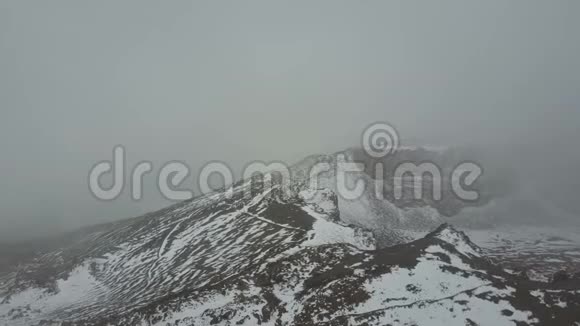 在特内里费的维约火山火山口的空中视野覆盖着雪和云视频的预览图