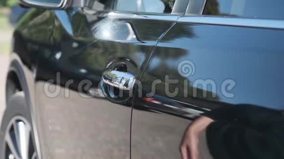 一个女人打开她的新黑色汽车的门在经销店买了那辆车视频的预览图