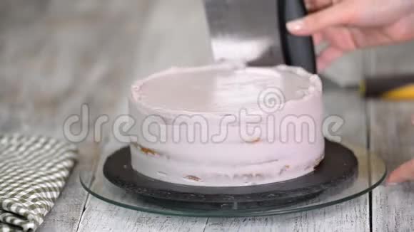 女孩把蛋糕上的奶油弄平了自制糕点烹饪糕点的概念视频的预览图