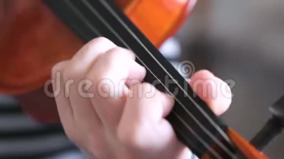 男孩手里小提琴男孩正在学习拉小提琴左手手指在琴弦上的正确设置视频的预览图