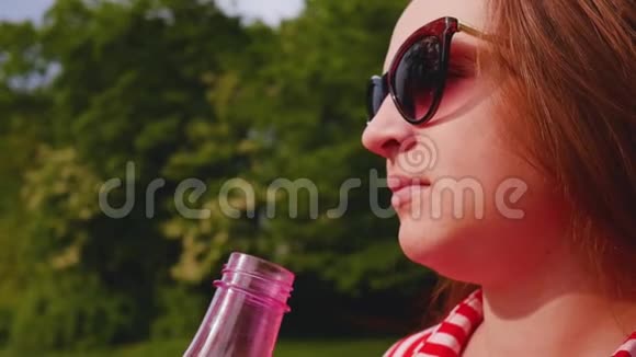 女人喝水肖像画的轮廓年轻口渴的女人长发饮水近距离射击视频的预览图