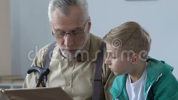 男性养老金领取者为孙子读故事书讲解学校科目帮助视频的预览图