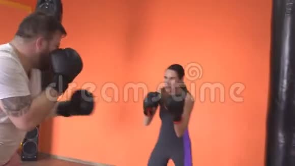 白种人男女在健身房拳击手套拳击训练视频的预览图