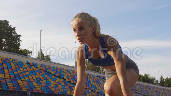苗条的金发运动员在运动场上跑步比赛前训练慢动作视频的预览图