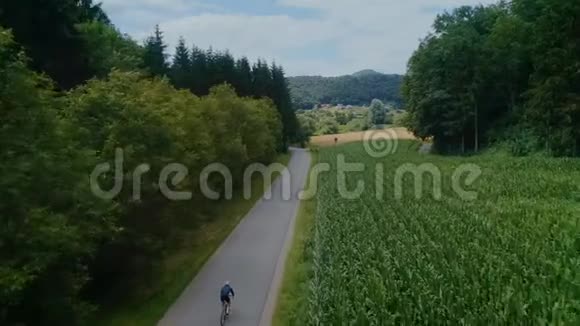 骑自行车的人骑自行车在森林田野路上视频的预览图