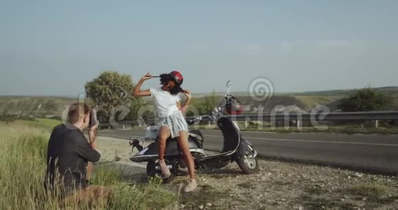 一位留着卷发的拉丁女孩正骑着摩托车为男友摆姿势视频的预览图