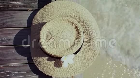 草帽放在靠近水面的木地板上防晒的概念视频的预览图