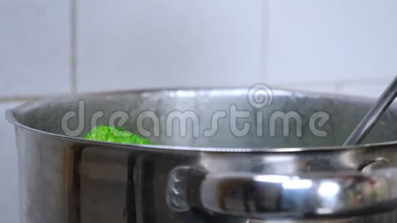 厨师或家庭主妇用脱脂器从一锅沸水中取出煮熟的西兰花视频的预览图