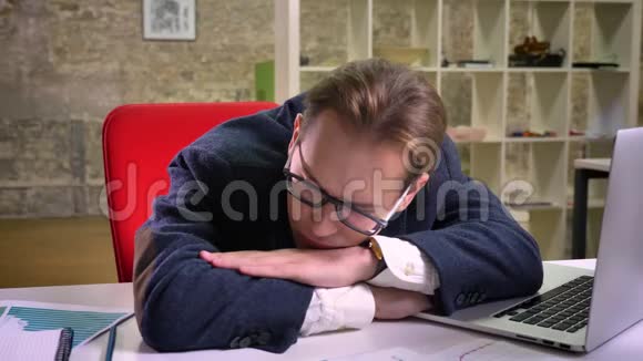冷静的白种人商人一个人睡在工作场所过了一段时间就继续用电脑工作视频的预览图