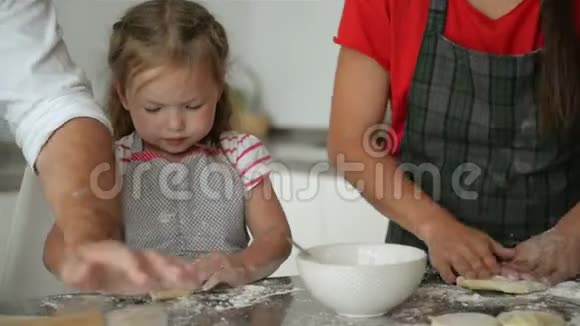 可爱的女儿正在帮助她的父母做饭烹饪过程一点点支持视频的预览图