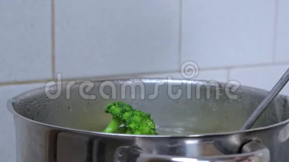厨师或家庭主妇用脱脂器从一锅沸水中取出煮熟的西兰花视频的预览图