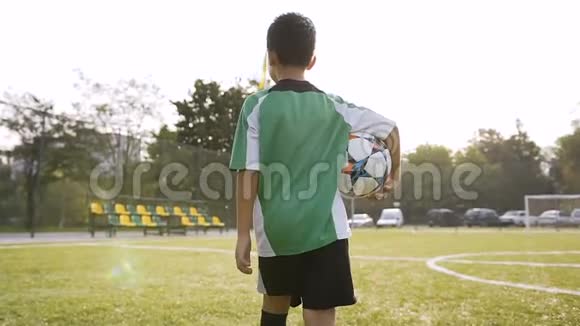 小男孩手里拿着足球走路视频的预览图