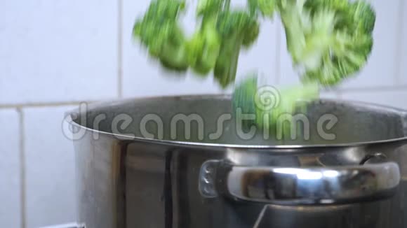 厨师或家庭主妇将新鲜的西兰花放入一锅沸水中视频的预览图