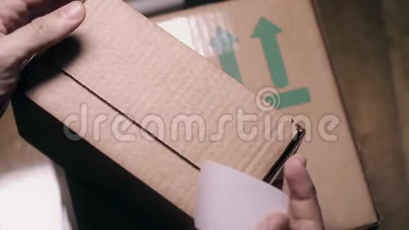 男士用白色贴纸密封包裹纸箱视频的预览图