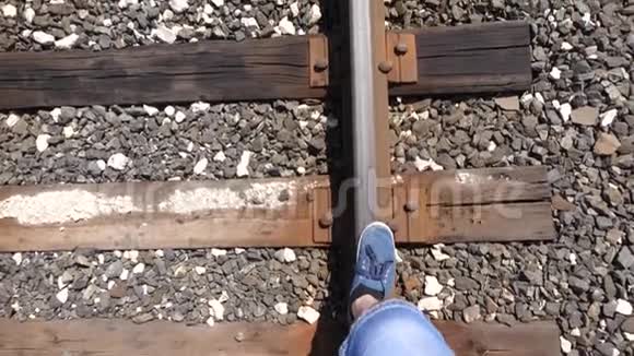 旅行者的腿在铁路上铁轨上行驶特写镜头游客在枕木上台阶乘客落在后面视频的预览图