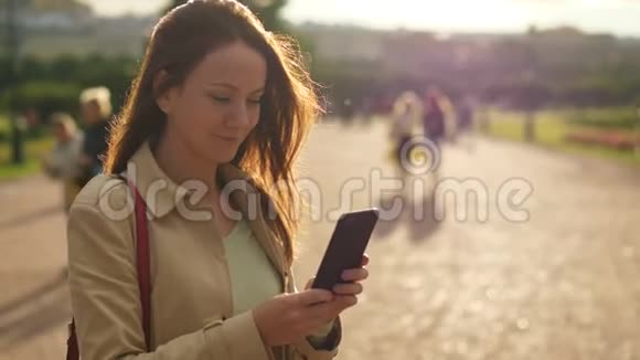 女性在智能手机上阅读信息在阳光下拍摄肖像视频的预览图
