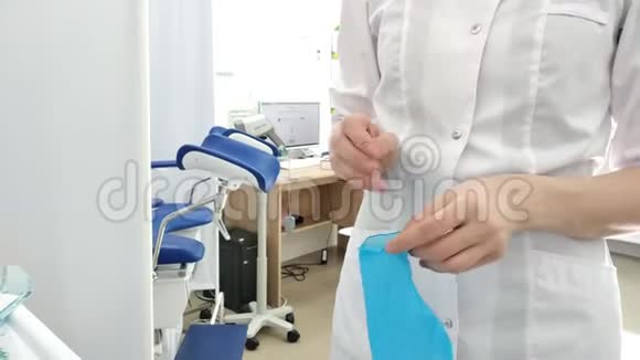 一位身穿白色制服的女医生在手术前戴上蓝色手套视频的预览图