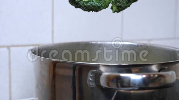 厨师或家庭主妇将新鲜的西兰花放入一锅沸水中视频的预览图