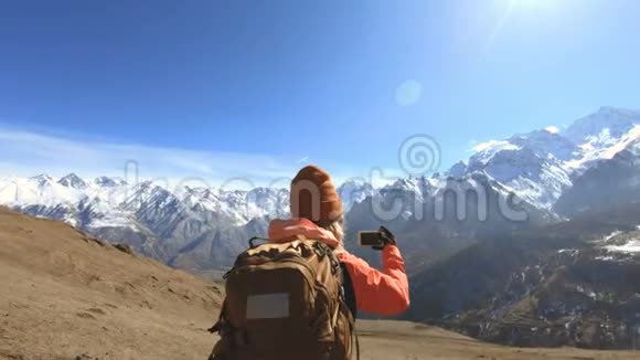 一位戴着帽子戴着墨镜脖子上戴着相机手机的快乐女旅行者的肖像视频的预览图