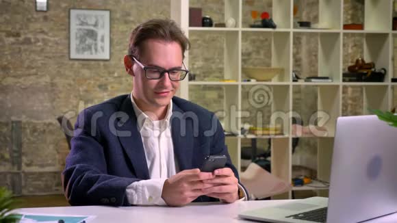 白种人商人一个人坐在白桌旁放松着脸上露出了一丝笑容视频的预览图