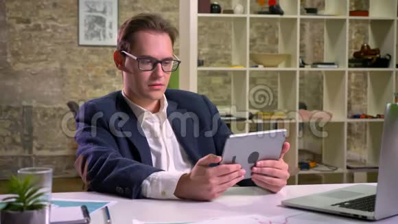 令人惊讶的白种人男性看着平板电脑却不动声色地呆在同一位置视频的预览图