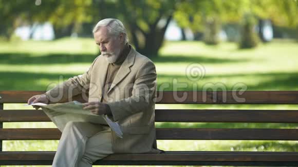 老年绅士在户外阅读新闻思考政治形势视频的预览图