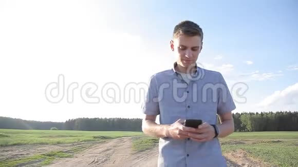 一个年轻人在智能手机上散步和写信息视频的预览图