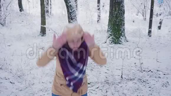 迷人的年轻女子在冬天的公园里跳着愚蠢而有趣的舞蹈玩得很开心微笑着慢动作视频的预览图