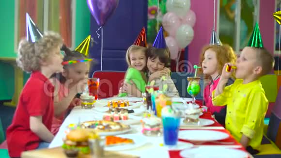 孩子们戴着五颜六色的帽子在娱乐中心庆祝生日视频的预览图