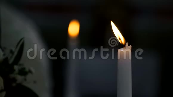 新郎在教堂里拿着蜡烛基督教婚礼镜头从一支蜡烛平稳地聚焦到另一支蜡烛视频的预览图