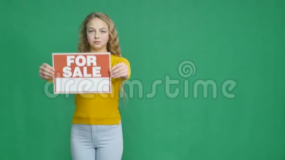 女孩展示了一个要出售标志视频的预览图