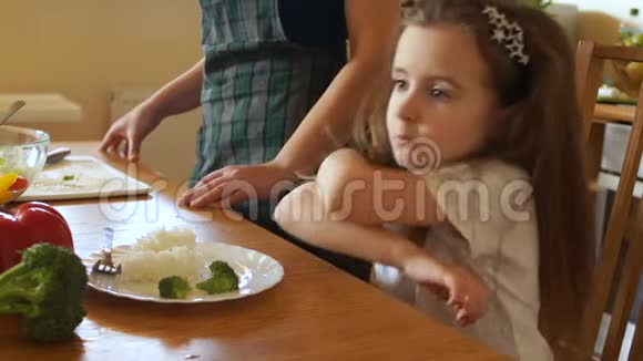 厨房里的女孩不想吃米饭和西兰花他的头悲伤地垂在手上视频的预览图
