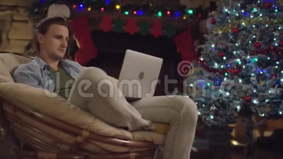 圣诞夜年轻的帅哥在笔记本电脑上打短信视频的预览图