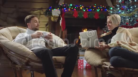 成年男子在圣诞夜喝咖啡和幸福的妻子用笔记本电脑聊天视频的预览图