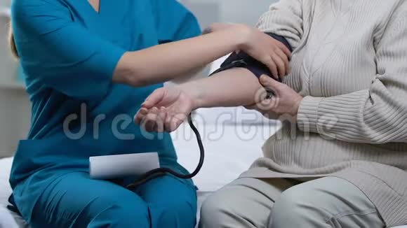 护士在养老院测量老年女性患者血压医疗视频的预览图