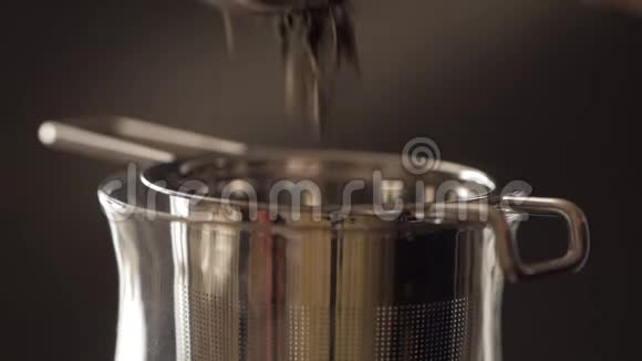 用金属过滤器在玻璃杯中冲泡茶水壶里的热水通过钢水过滤器流入玻璃视频的预览图