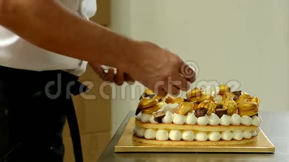 糖果师用金色糖果装饰美味的奶油蛋糕视频的预览图