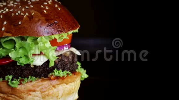 快餐红椒汉堡在黑色背景的木板上慢慢旋转视频的预览图