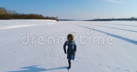 女人跑在积雪覆盖的地方空中录像视频的预览图