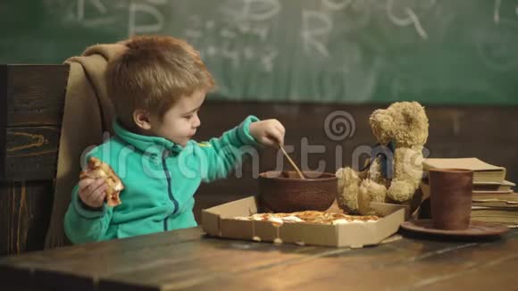 喂养概念小孩子在学校喂泰迪熊男孩在教室里喂食和照顾玩具朋友视频的预览图